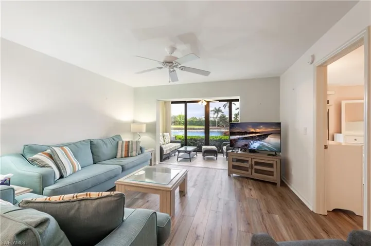 Living room with ceiling fan and light hardwood / wood-style flooring