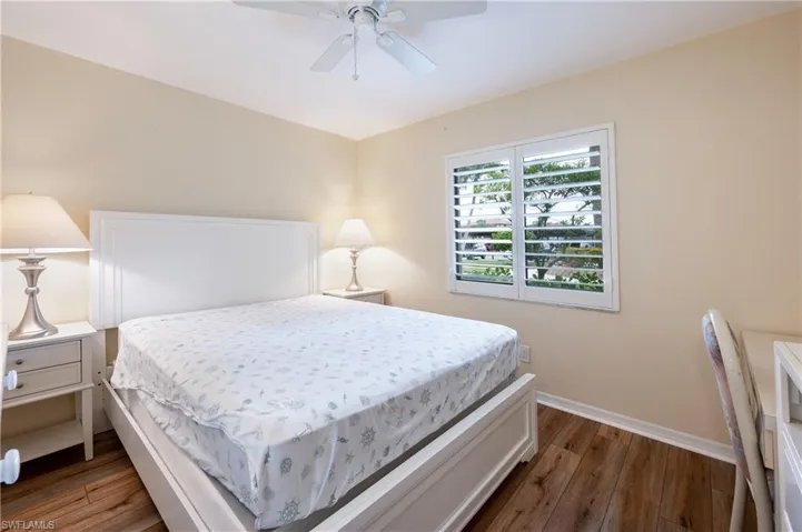 Bedroom with ceiling fan and dark hardwood / wood-style floors