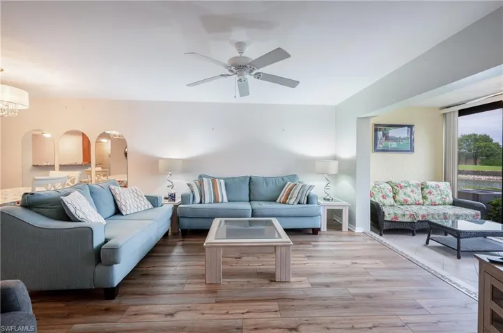 Living room with ceiling fan with notable chandelier