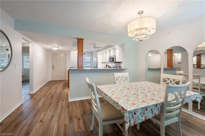 Dining area with ceiling fan with notable chandelier and light hardwood / wood-style flooring