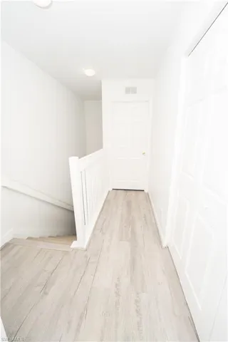 Corridor featuring light wood-style floors and an upstairs landing