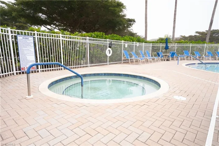 View of swimming pool with a hot tub, a swimming pool, and a patio area