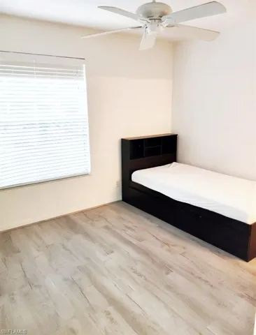 Unfurnished bedroom with ceiling fan and light wood-type flooring