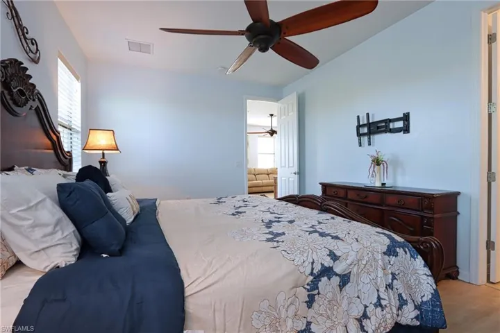 Bedroom with multiple windows, ceiling fan, and light hardwood / wood-style floors