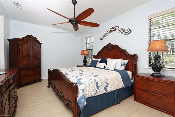 Bedroom featuring light hardwood / wood-style flooring, ceiling fan, and multiple windows