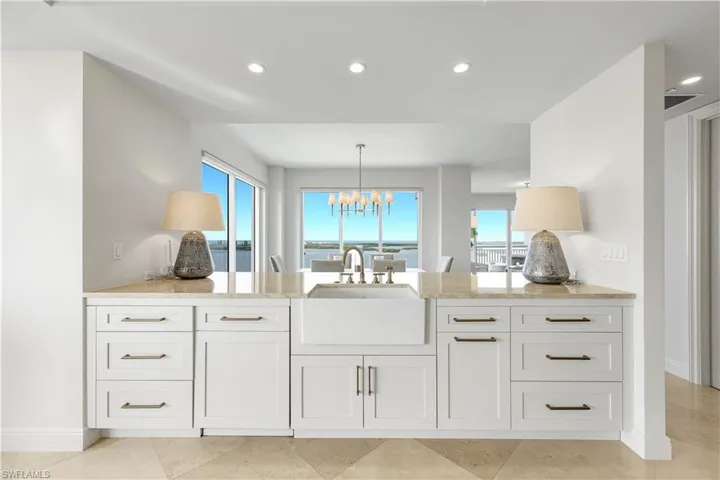 Enjoy sweeping water views from the kitchen, where updated appliances and timeless white cabinetry create a bright and refined culinary space.