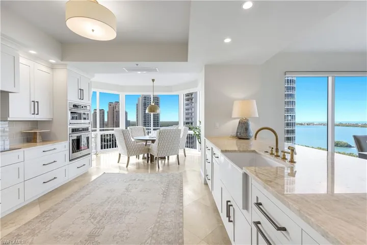 Beautifully updated kitchen features white cabinetry, generous counter space, and expansive views.