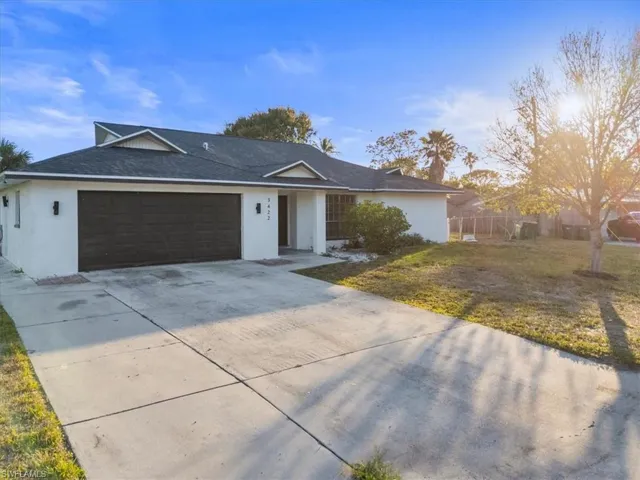 Single story home featuring a garage and a front yard