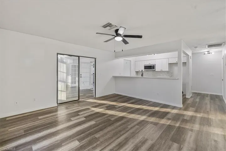 Unfurnished living room featuring dark hardwood / wood-style floors and ceiling fan