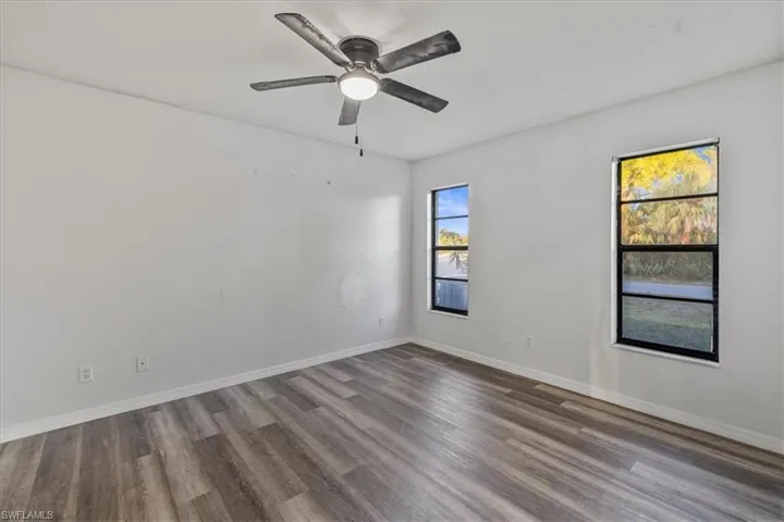 Empty room with hardwood / wood-style flooring and ceiling fan