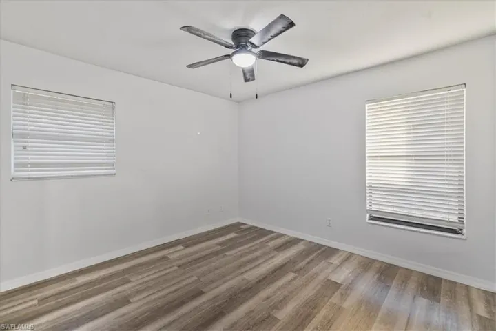 Empty room featuring hardwood / wood-style flooring and ceiling fan