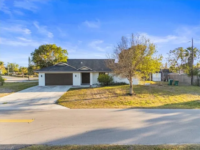 Single story home with a garage and a front yard