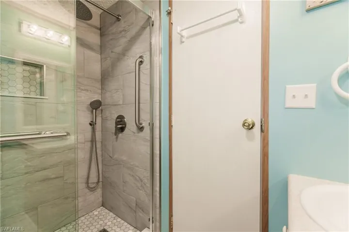 Bathroom featuring vanity and a shower with door
