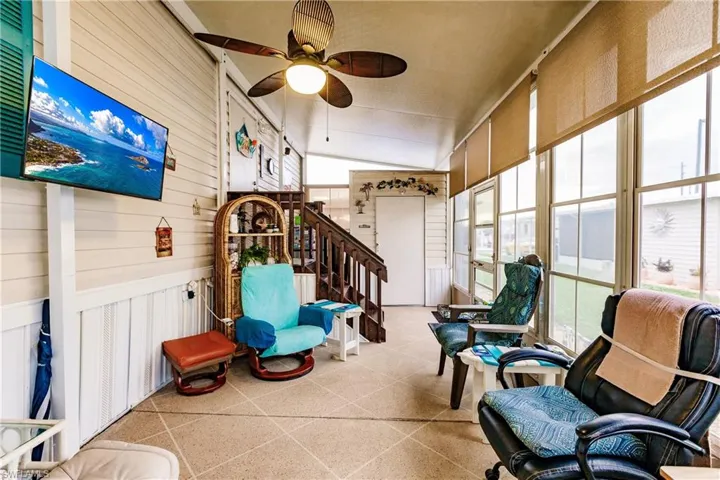 Sunroom with a wealth of natural light, ceiling fan, and vaulted ceiling