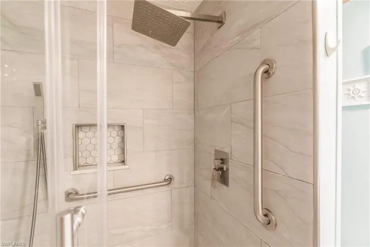 Shower has extra saftey and convenienc efeatures- note grab bar, shelf insert, and hanheld shower in addition to rain shower head