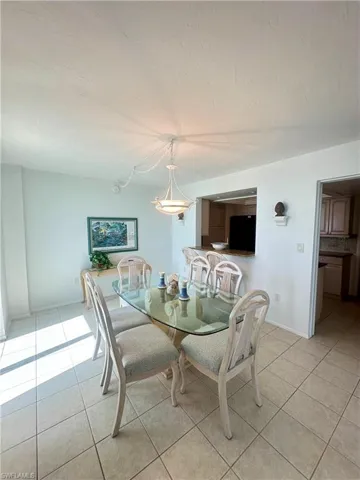 Kitchen with a sink, a tray ceiling, black appliances, and decorative backsplash