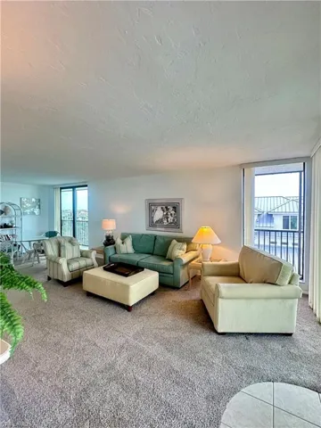 Carpeted living room with a textured ceiling