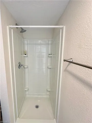 Living area with baseboards, a wall mounted air conditioner, and ceiling fan