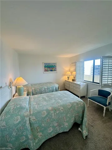 Bedroom with dark colored carpet and a textured ceiling