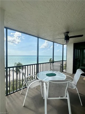 Sunroom / solarium with a water view and ceiling fan
