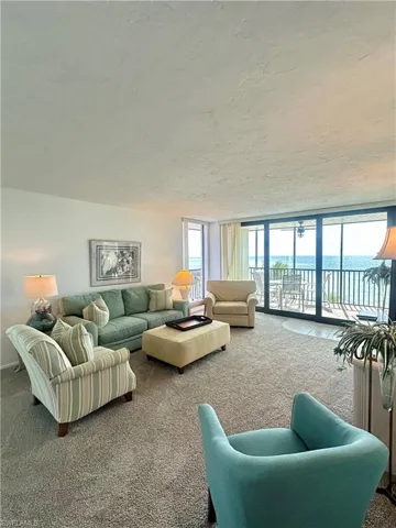 Living room featuring floor to ceiling windows, carpet floors, and a textured ceiling