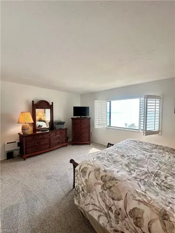 Carpeted bedroom with baseboards and a textured ceiling