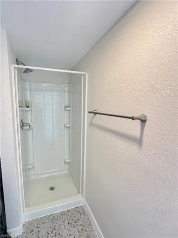 Living area featuring baseboards and ceiling fan