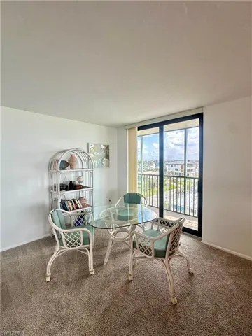 Carpeted dining space with baseboards and floor to ceiling windows