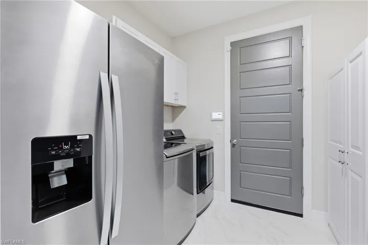 Well appointed laundry room with built-in cabinetry and storage