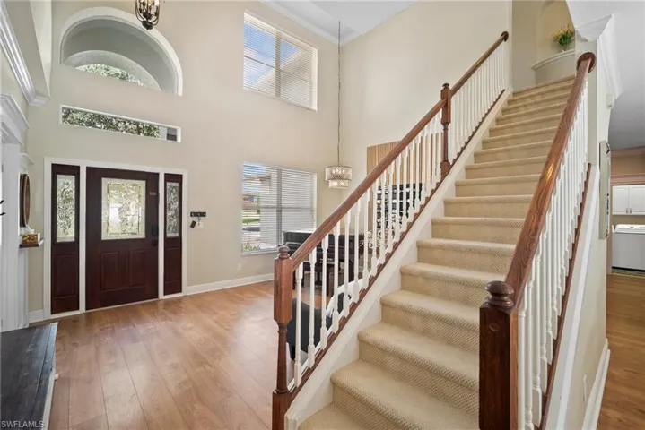 Foyer entrance with a chandelier, hardwood / wood-style flooring, and a high ceiling