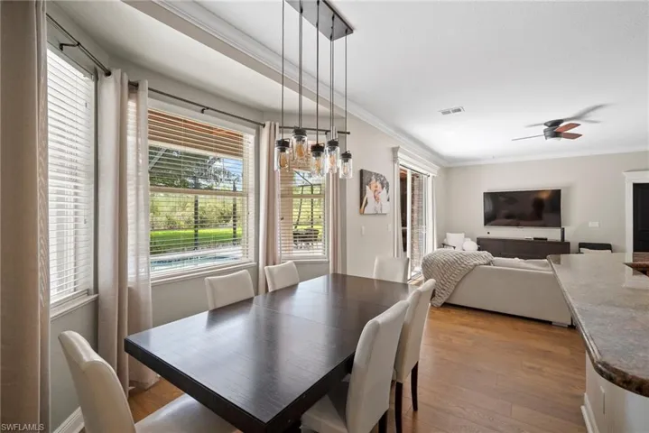 Dining room with ceiling fan, light hardwood / wood-style flooring, and ornamental molding
