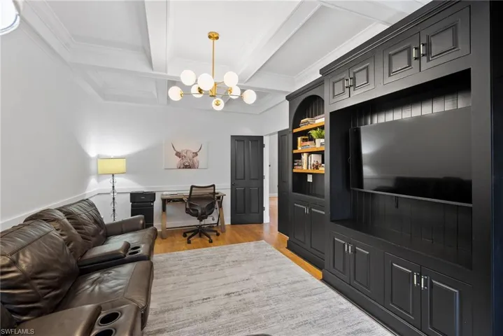 Home office with coffered ceiling, ornamental molding, a chandelier, light hardwood / wood-style flooring, and beamed ceiling