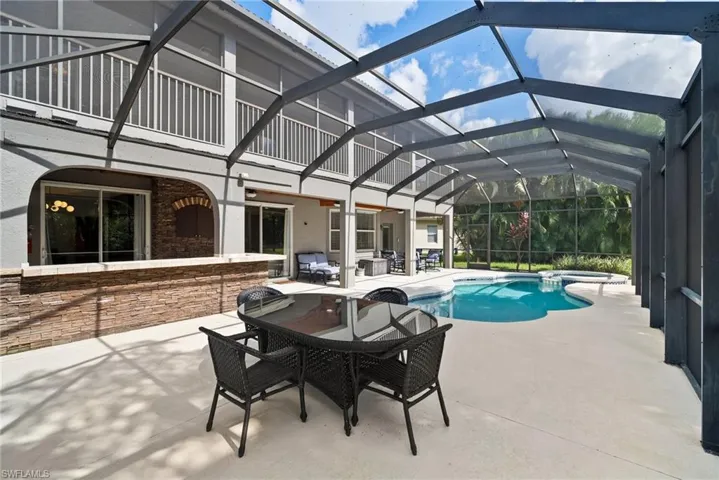 View of pool featuring glass enclosure and a patio