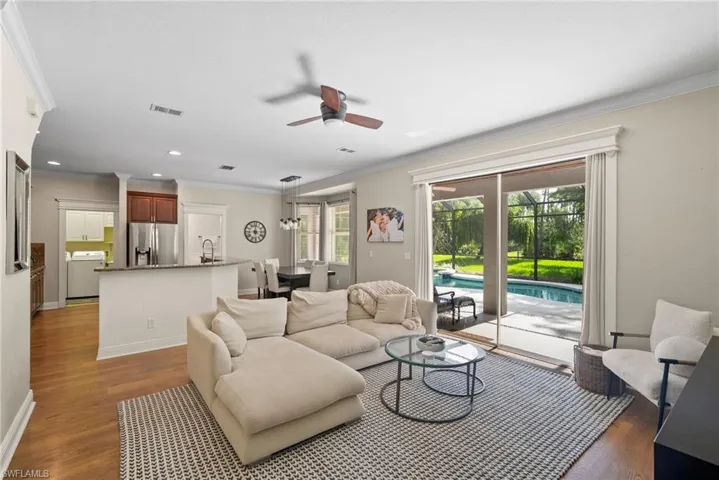 Living room featuring ceiling fan, ornamental molding, and light hardwood / wood-style floors