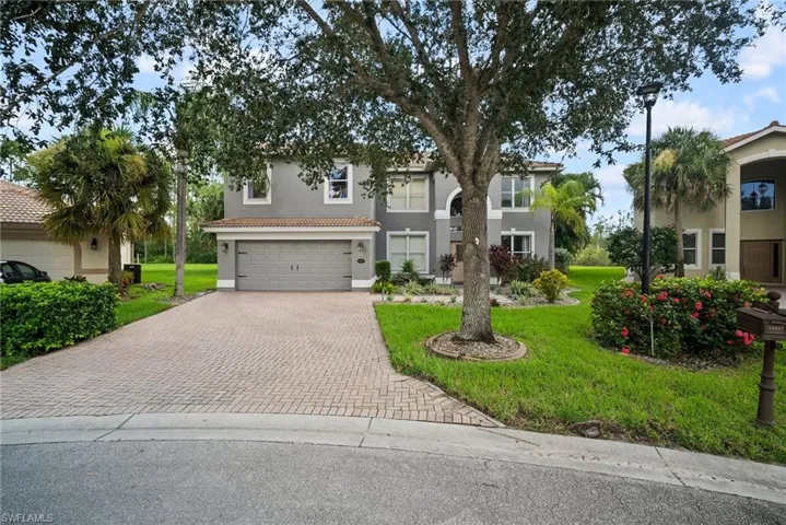 Mediterranean / spanish-style house with a garage and a front lawn