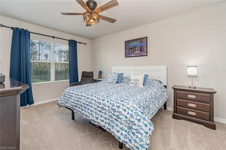 Carpeted primary bedroom featuring ceiling fan light