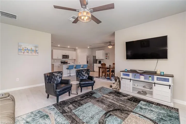 Living room featuring plank tile floors and ceiling fan light