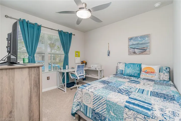 Carpeted bedroom with upgraded ceiling fan light