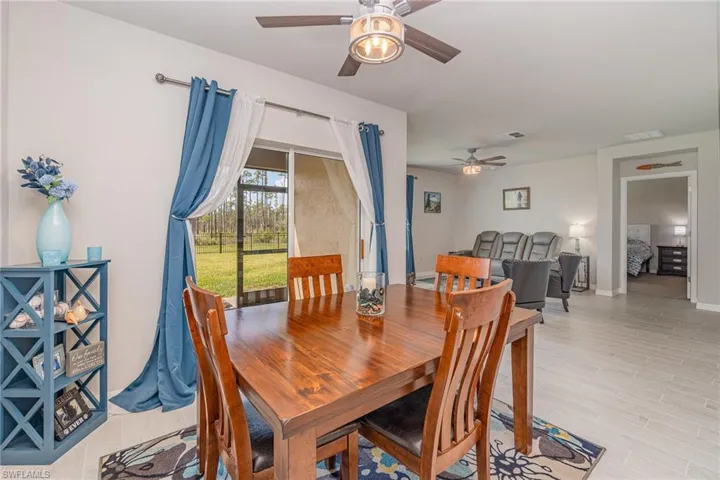 Dining room with light plank tile floors and ceiling fan light