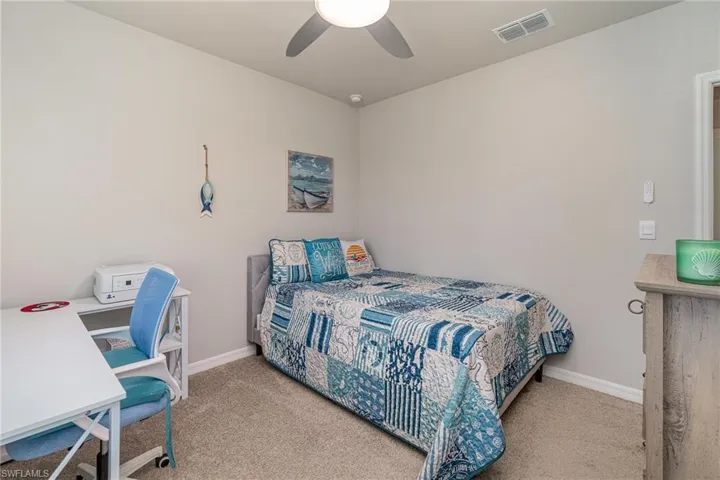 Carpeted bedroom with upgraded ceiling fan light