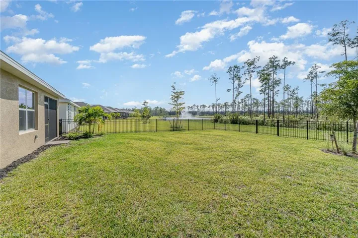 View of fenced yard and water feature