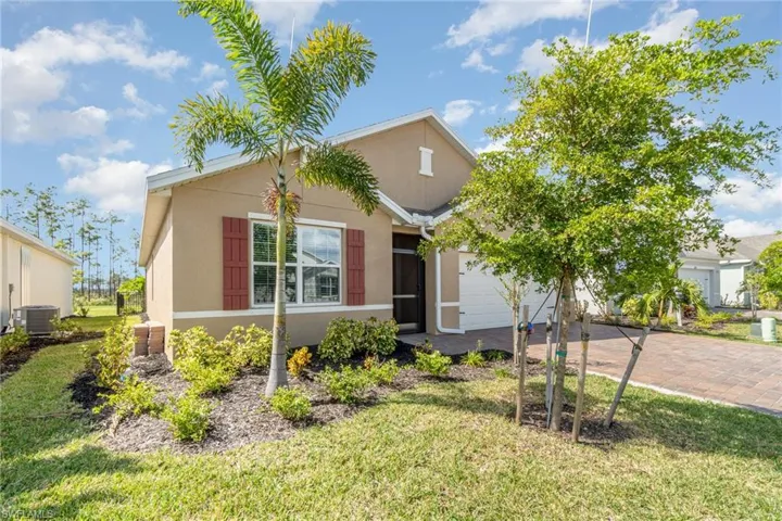 View of front of home with a front yard, a garage, and central AC unit