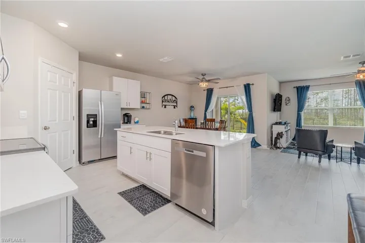 Kitchen with white cabinetry, a kitchen island with sink, stainless steel appliances, and a wealth of natural light