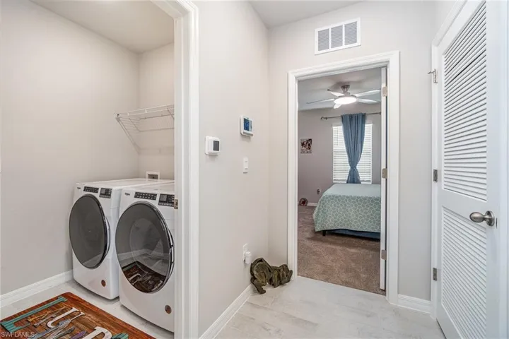 Washroom with light plank tile floors, washer and dryer