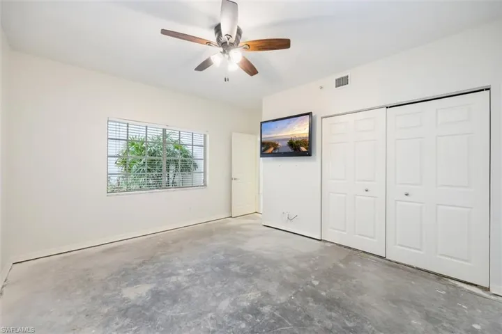 Unfurnished bedroom featuring unfinished concrete floors, a closet, and ceiling fan