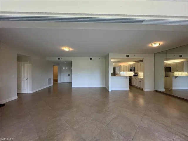 Unfurnished living room featuring baseboards
