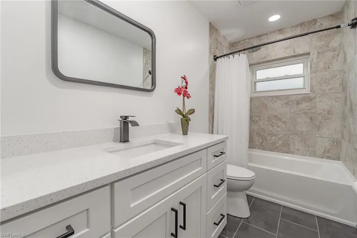 Full bathroom with tile patterned flooring, vanity, toilet, and shower / bath combo
