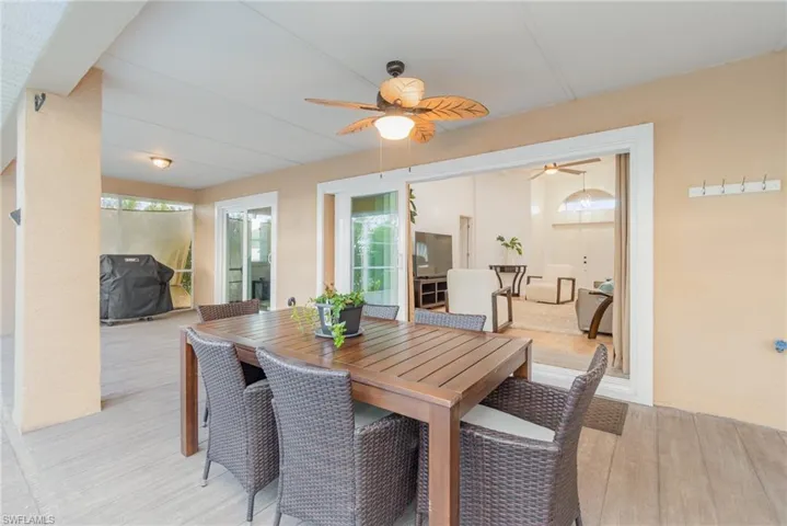 Lanai with plenty of room for table and seating area with ceiling fan and concrete flooring to look like wood