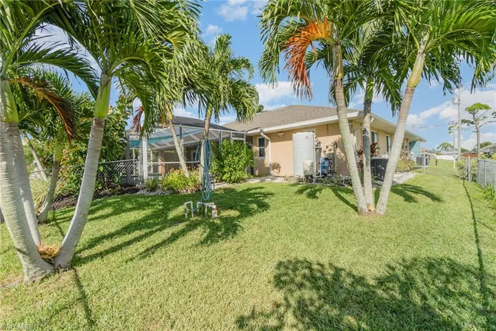Rear view of house with a lawn and a lanai