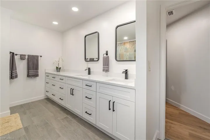 Bathroom with dual sink vanity and hardwood / wood-style floors